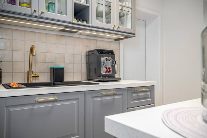 Moderne graue Einbauküche mit Kaffeevollautomat